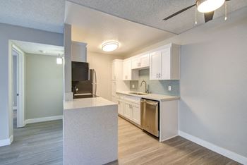 A renovated kitchen with white cabinets and stainless steel appliances